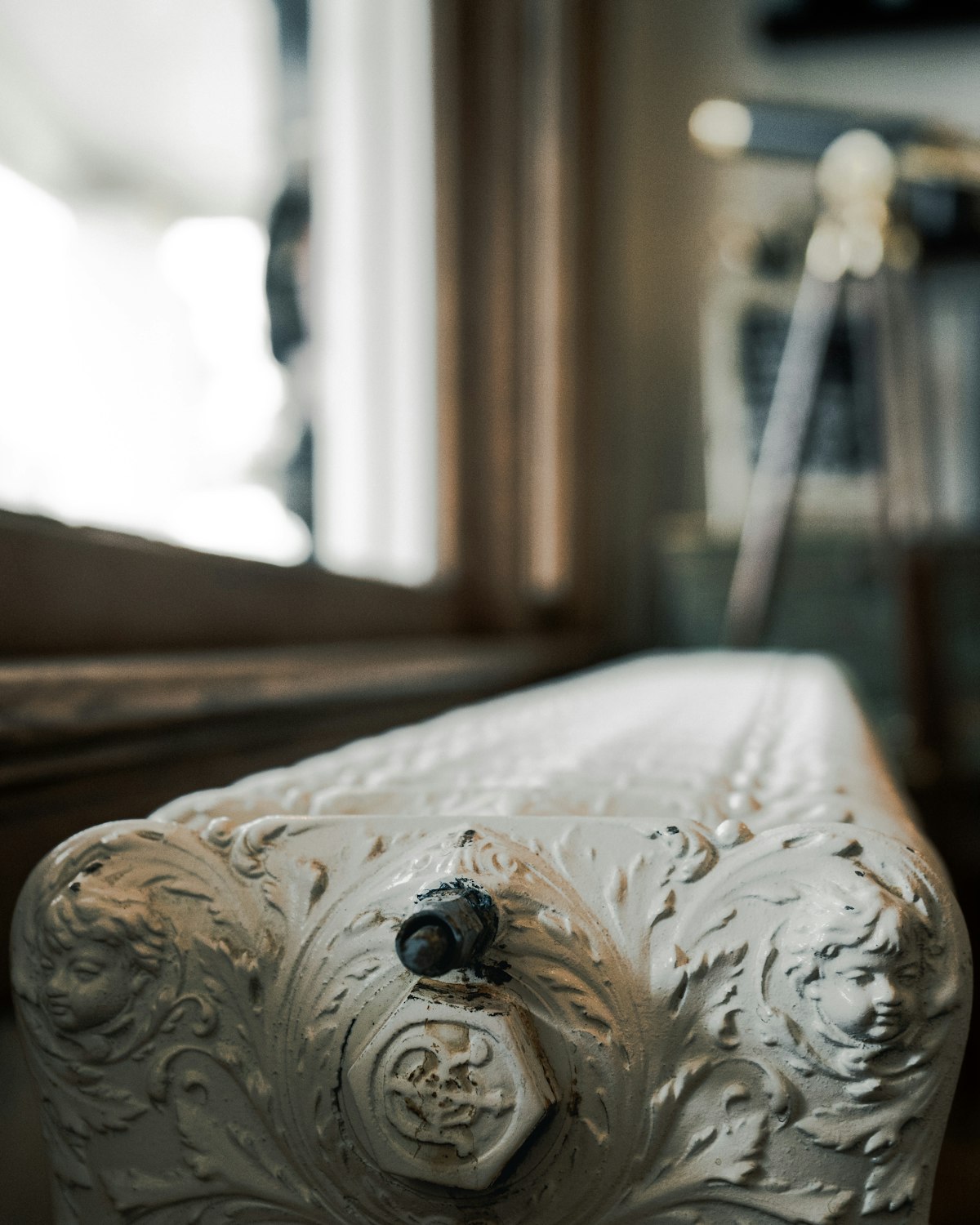 Ornate cast iron radiator under a window after restoration and re-plumbing